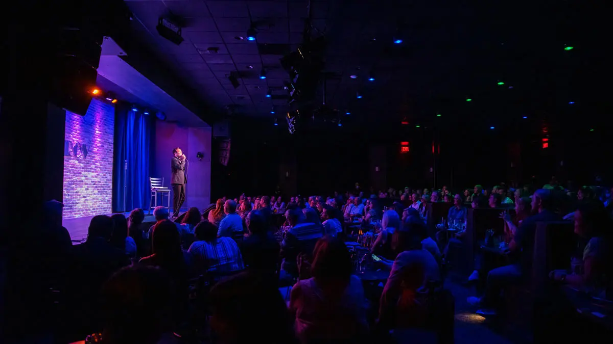 A crowd of people sitting in front of a microphone.